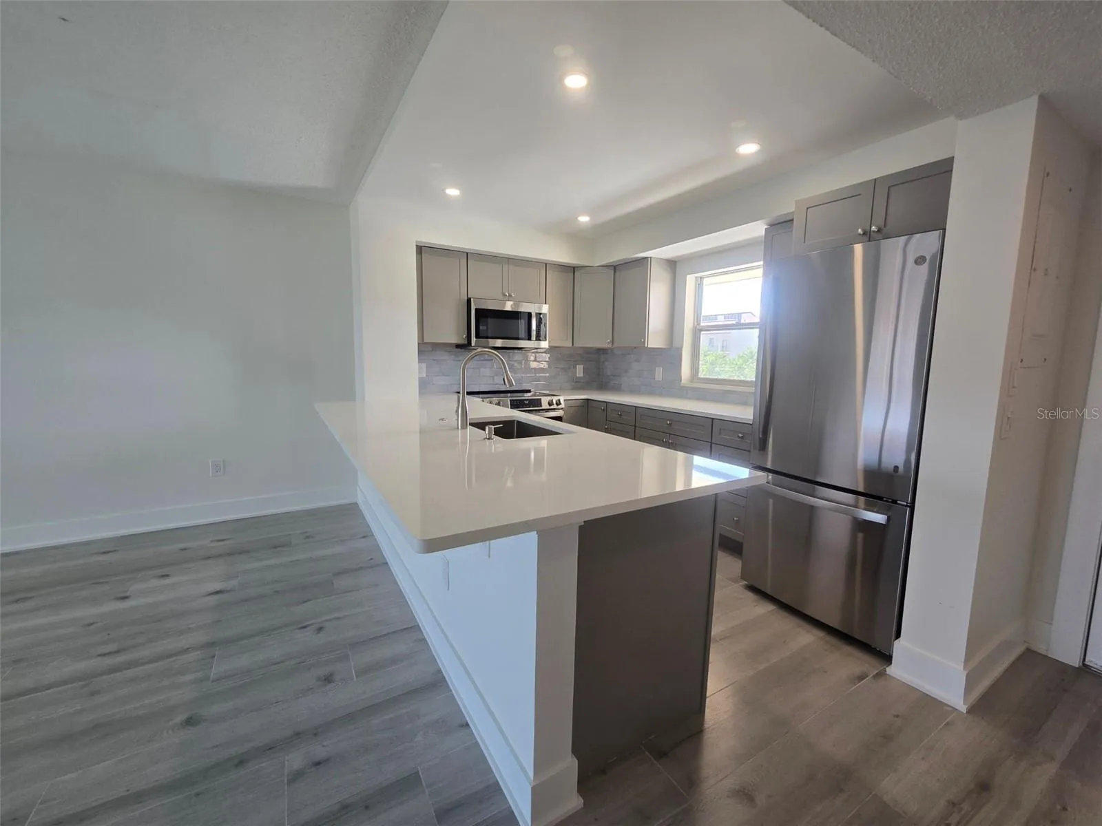 Beautiful New Kitchen with indirect lighting large quartz counter perfect for a few stools