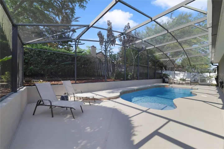 View of pool, deck and screened enclosure
