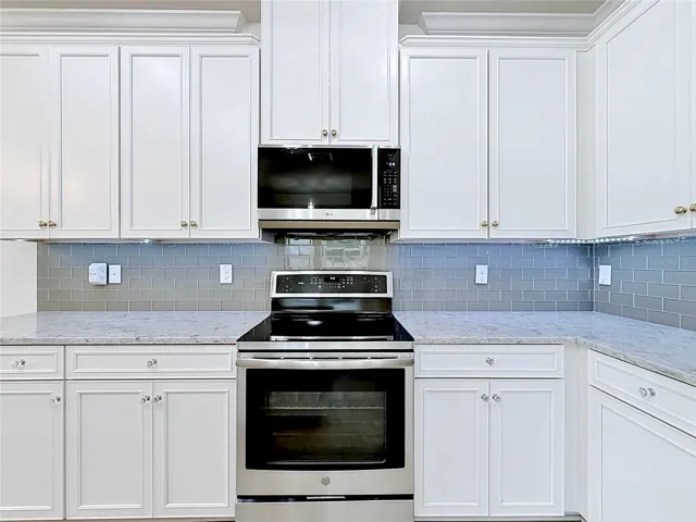 Kitchen has upgraded appliances, granite counters, tile backsplash