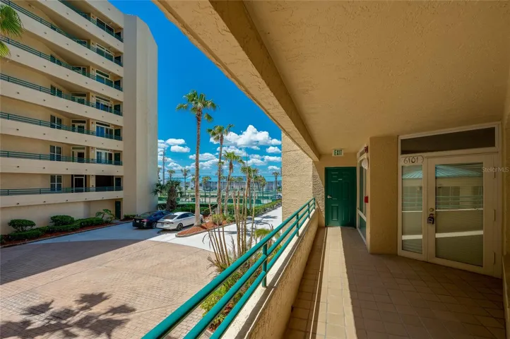 Covered exterior walkway provides convenient access to the unit, with views of the surrounding grounds and nearby amenities.