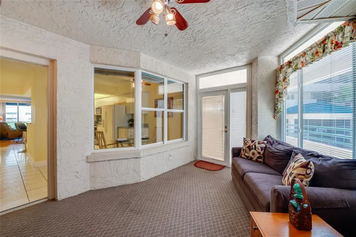Another angle of the sunroom highlights its versatile layout, with large windows and a view to the inside, creating a seamless indoor-outdoor living experience.
