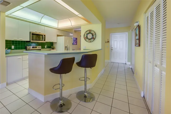 A convenient breakfast bar with seating provides the perfect spot for casual meals or entertaining guests, while maintaining an open flow to the kitchen.