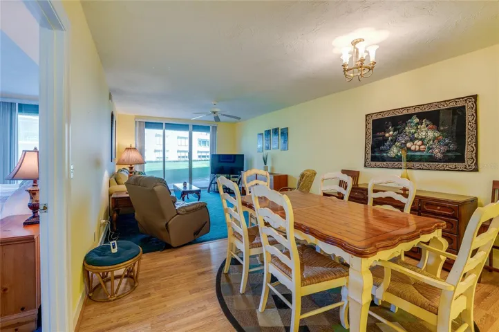 The combined living and dining area offers a spacious layout with large sliding glass doors that bring in natural light and provide access to outdoor views, ideal for both relaxing and hosting.