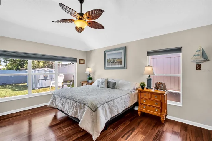 Massive primary retreat featuring soaring vaulted ceilings and oversized windows with peaceful pool views~