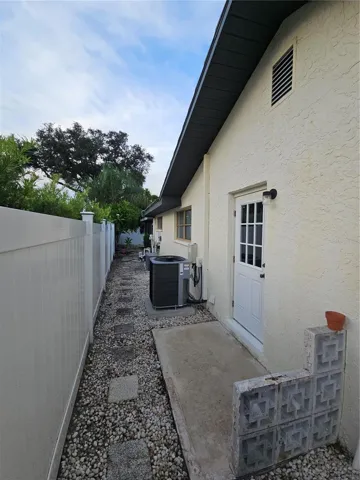 West Side of Home with door to laundry, AC, NEW Pool Pump and door to screened in pool.