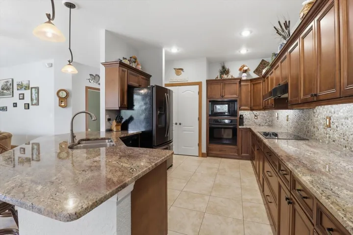 Kitchen Features Maple Cabinets, Granite Countertops, River Rock Backsplash, Cooktop w/ Separate Wall Oven, Breakfast Bar & Pantry Closet...Frig DOES NOT CONVEY