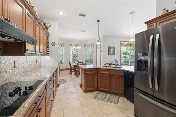 Kitchen Features Maple Cabinets, Granite Countertops, River Rock Backsplash, Cooktop w/ Separate Wall Oven & Pantry Closet... Frig DOES NOT CONVEY