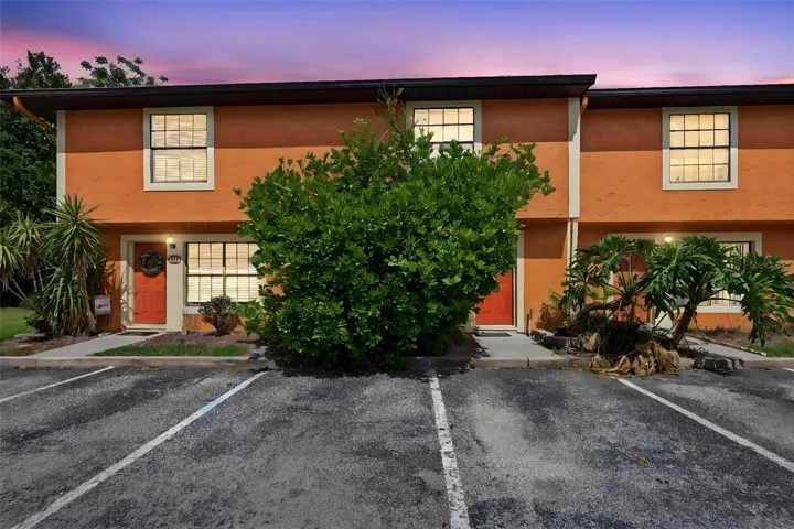 Two-story townhome-style exterior with stucco finish, private entry, and assigned parking steps from the front door.