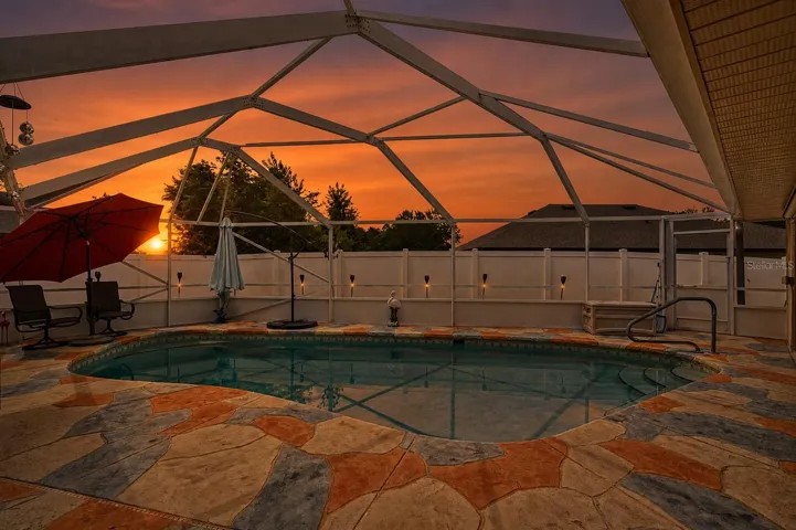 Screened lanai and pool with decorative stamped concrete, designed for year-round Florida living and entertaining