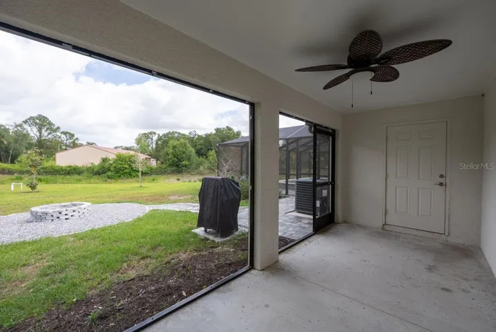 screened lanai off kitchen with walkway to pool and firepit