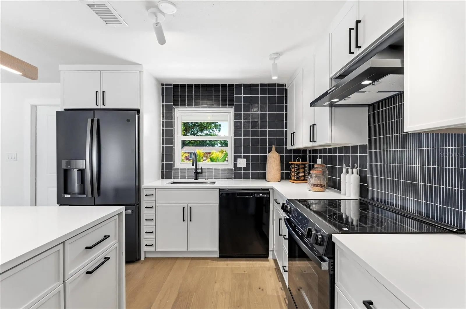The ceramic and stone backsplash adds a contrast to the quartz countertops as well as the floor.
