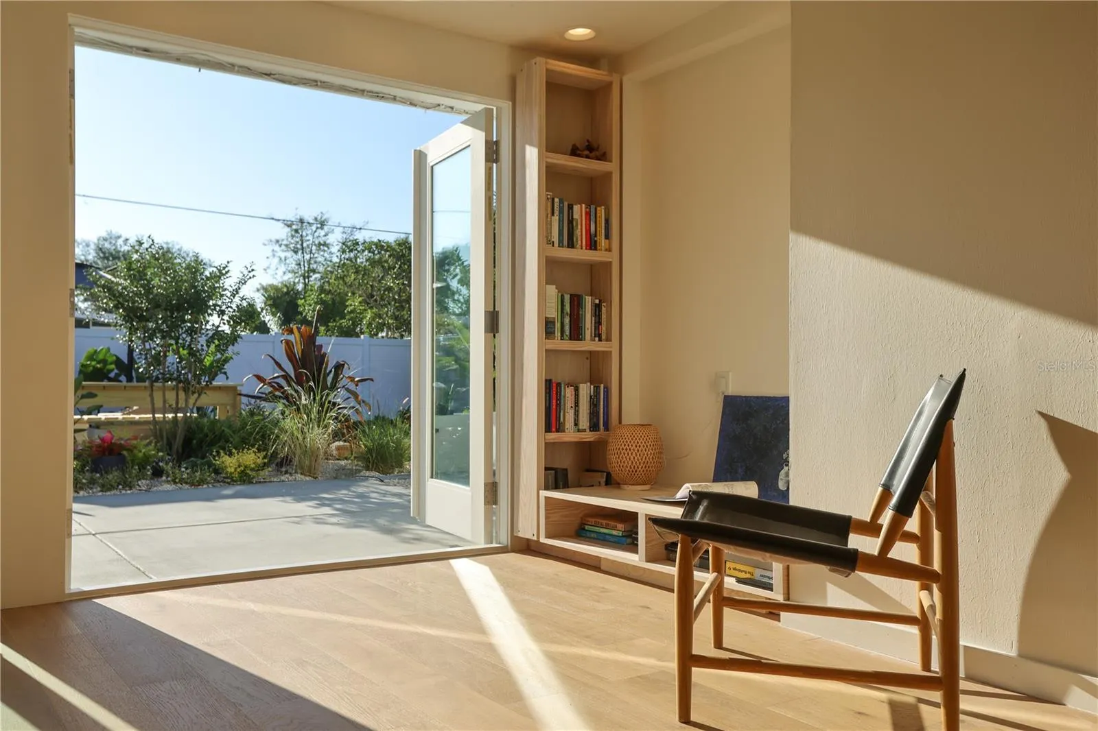 The living/dining room opens fully to the patio/yard through window doors, transforming the entire area into an outdoor extension ideal for gatherings