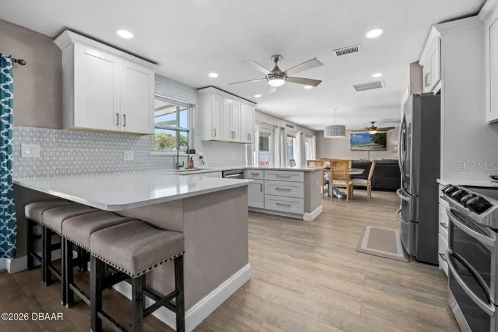 Kitchen with Bar Top Seating and Living Room Beyond