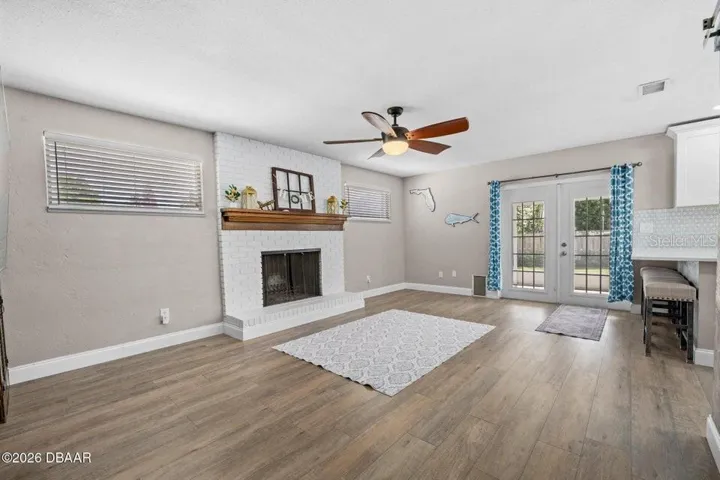 Family Room with Fireplace, French Doors to Screen Lanai and Pool