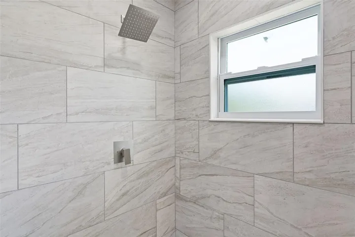 Primary shower with ceramic tile and rain shower head
