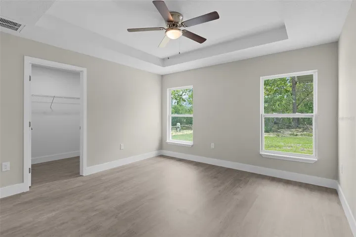 Primary bedroom with windows facing the back yard