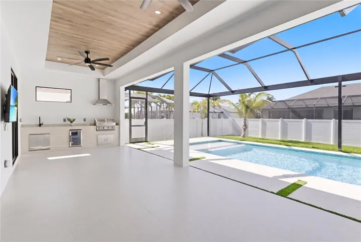 Expansive screened lanai with a fully equipped outdoor kitchen, perfect for year-round entertaining, dining, and enjoying Southwest Florida’s indoor-outdoor lifestyle