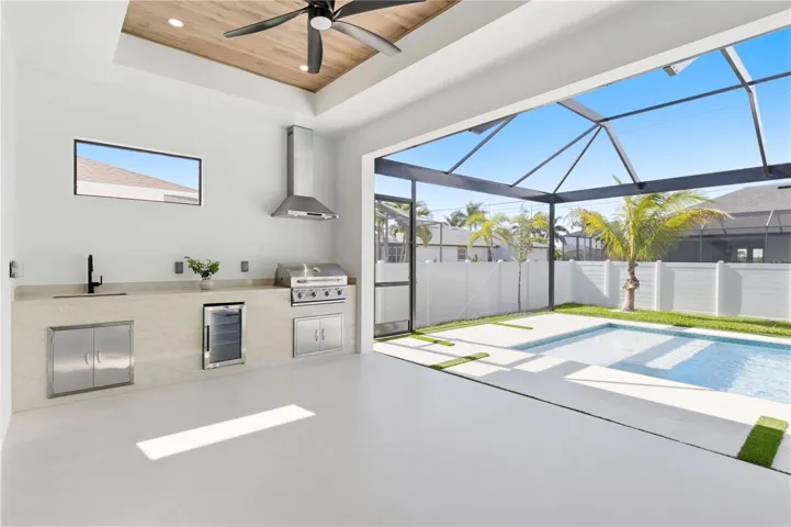 OUTDOOR KITCHEN w/ TAJ MAHAL-inspired quartz countertop, SS BULL 4-BURNER propane grill, beverage refrigerator & commercial sink