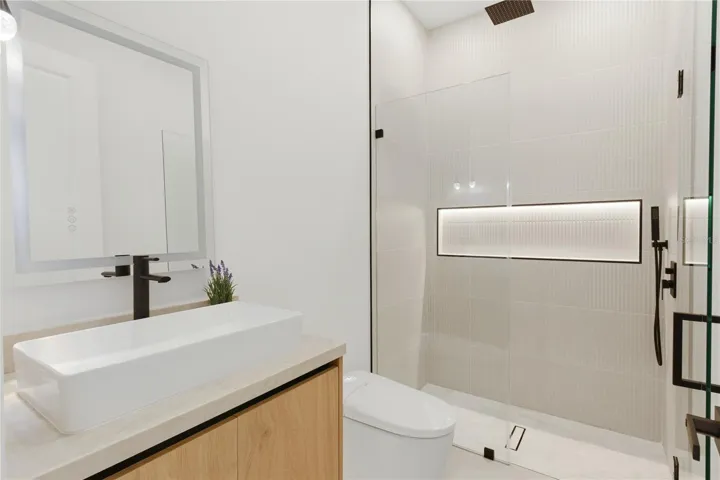 Well-appointed hallway bathroom featuring modern finishes, a sleek vanity, and convenient access for guests and everyday use
