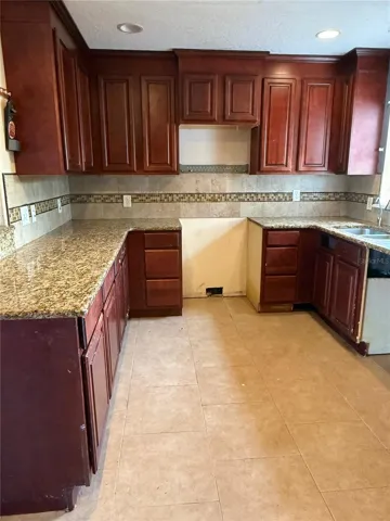 wood cabinets, granite countertops and pendant lighting