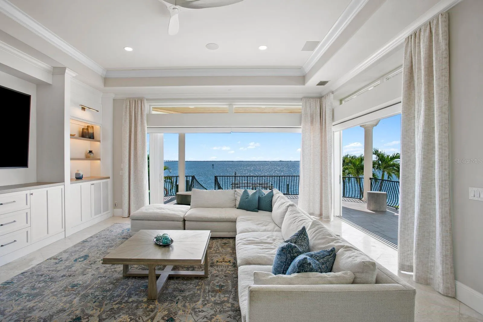 Another stunning perspective of the family room showcasing the fully opened sliders and seamless indoor-outdoor living.