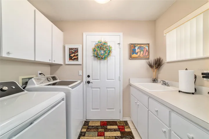 Laundry room with utility sink and cabinetry