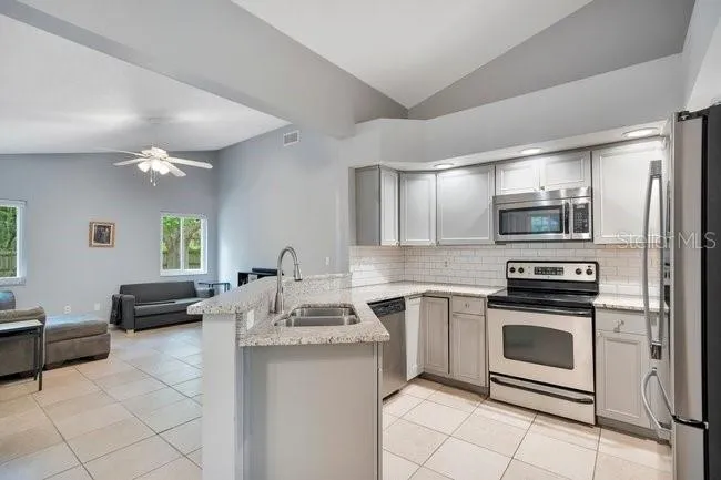 Kitchen with granite countertops, open to the family room—perfect for staying connected while cooking.