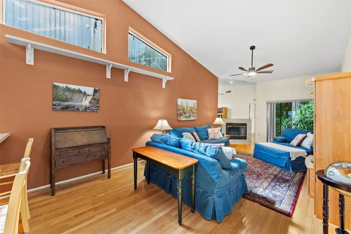Spacious living room with vaulted ceilings, wood flooring, and sliding glass doors.