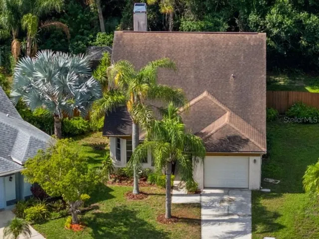 Aerial view highlighting the home’s lot, roofline, and established neighborhood setting.