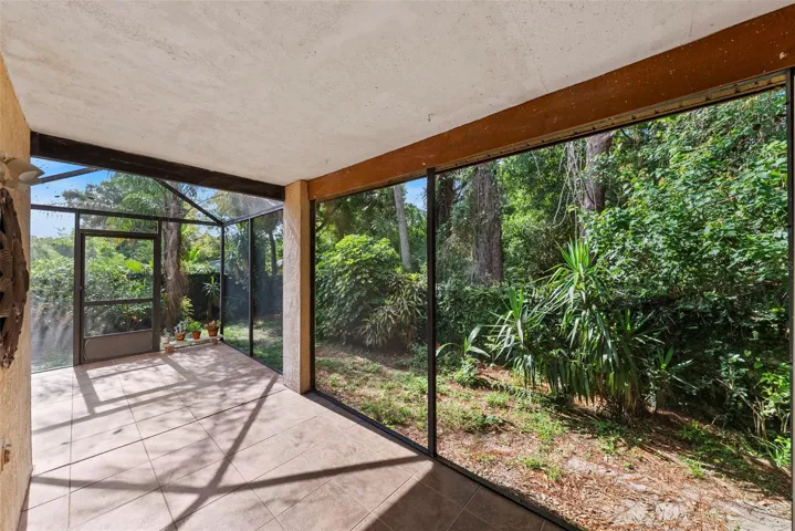 Screened lanai overlooking a private, natural backyard setting.