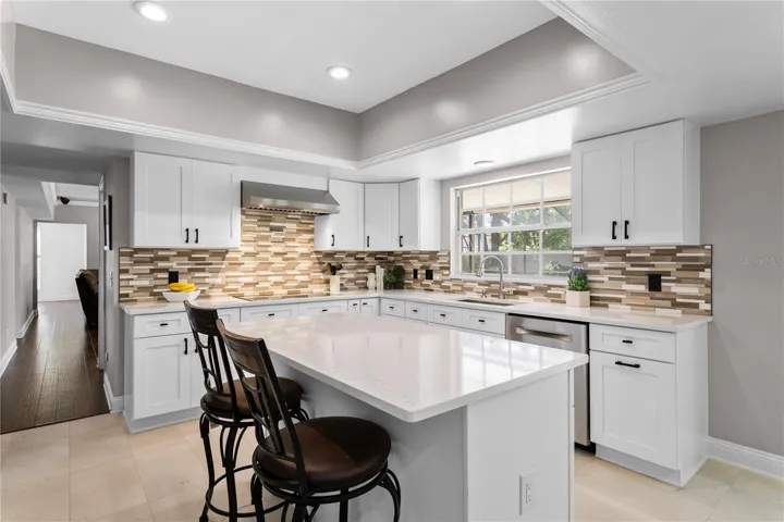 Kitchen features a large center island with breakfast bar