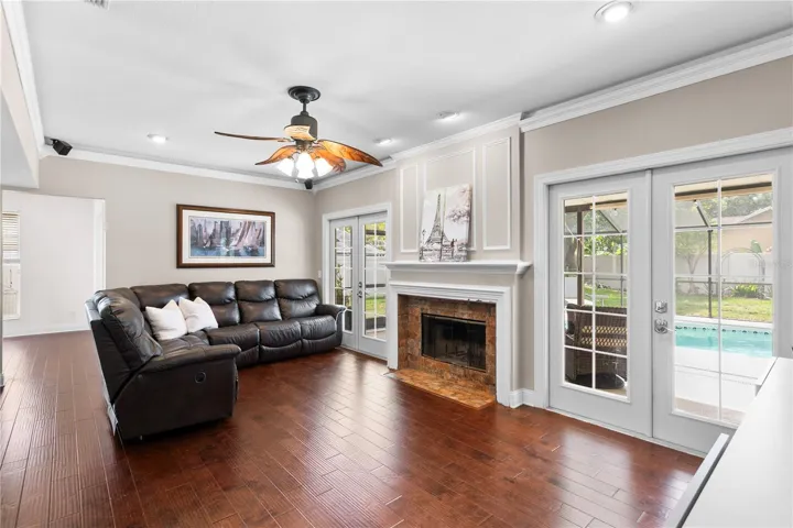 Family room features crown molding and a ceiling fan