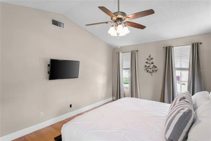 Large windows and ceiling fan in primary suite