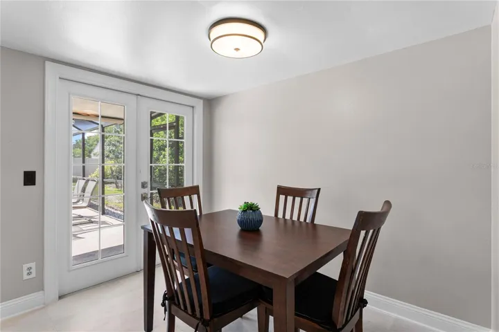 Casual dining area with french doors leading to the lanai and saltwater pool