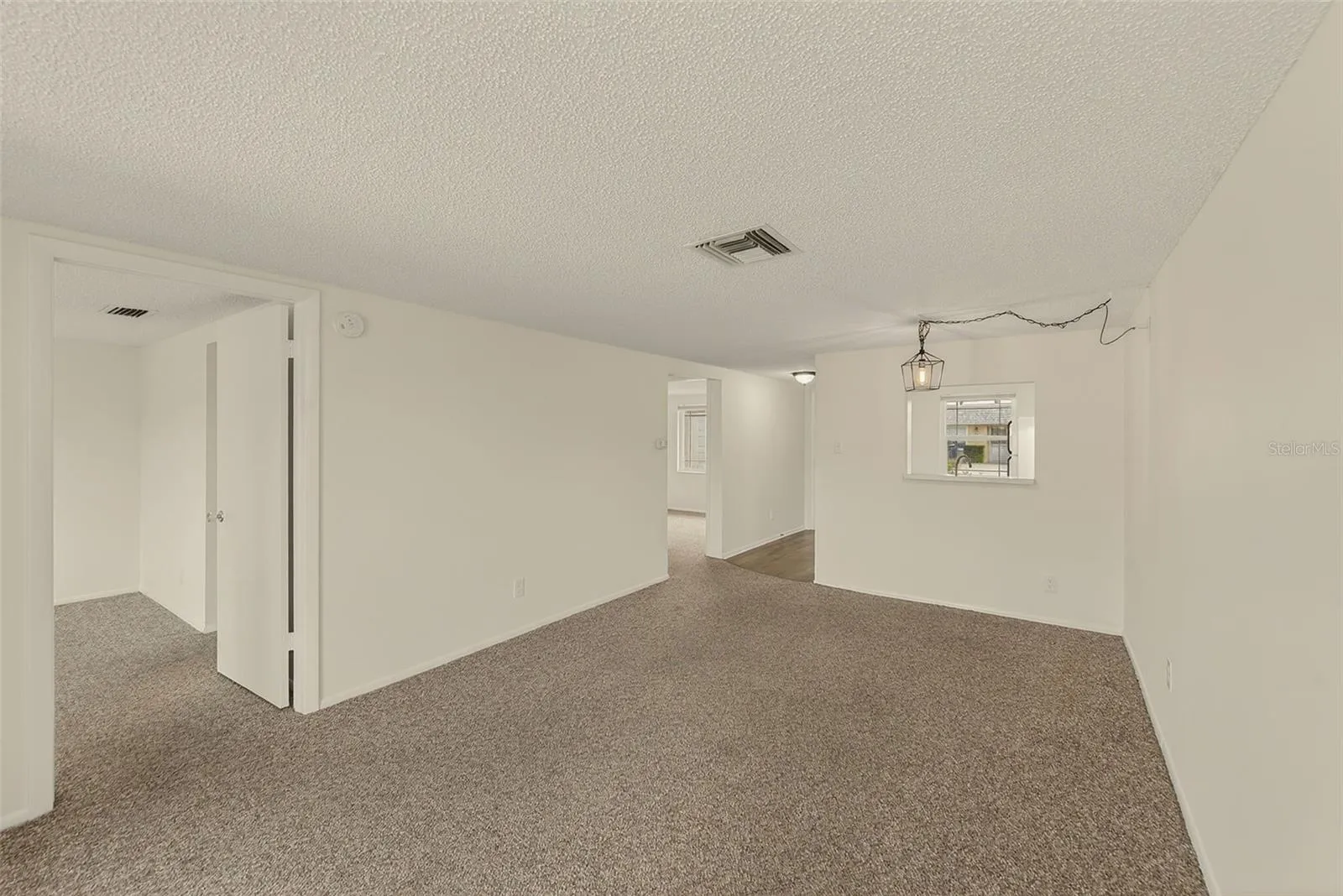 View of living/dining room with view of bedrooms