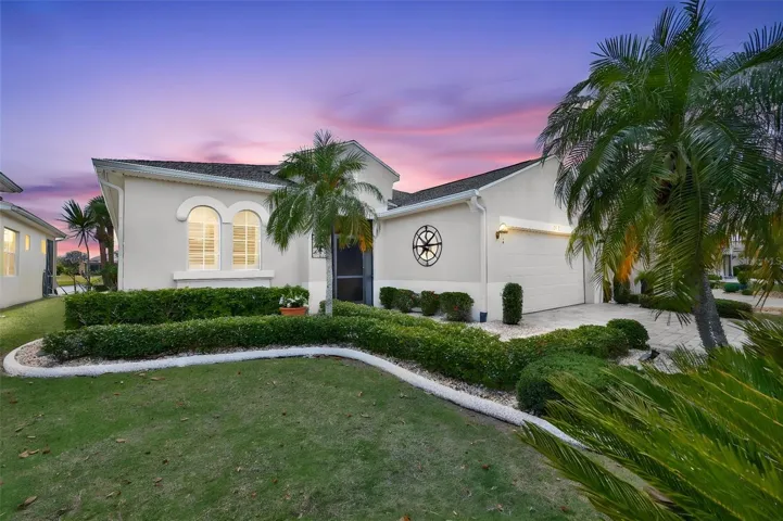 Beautifully maintained Floridian landscaping, front screened porch and arched entrance.