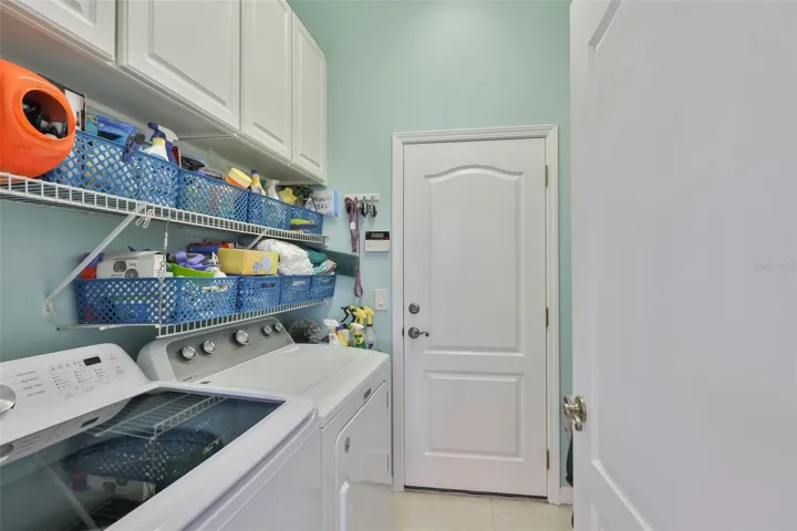 Laundry room is inside with cabinets and shelvings