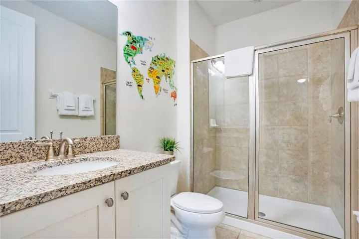 Well-appointed ensuite bath (#6) with granite vanity and tiled walk-in shower