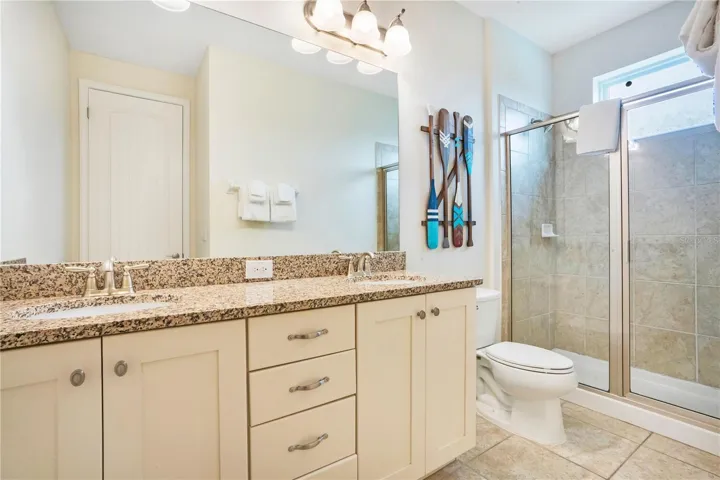 Luxury ensuite bathroom (#7) with dual vanities, granite counters, and oversized shower