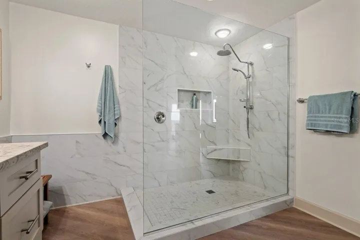 A spacious walk-in shower paired with a clean, timeless design creates a primary bath that feels both classic and enduring.
