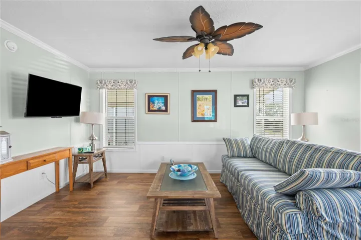 Nice living with ceiling fan and upgraded flooring.