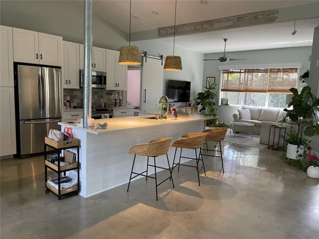 Stainless appliances in the kitchen with amazing light fixtures and matching chairs around the island.