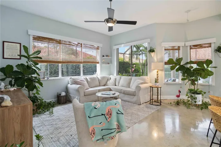 Here is the living room with a ceiling fan.  The shades and the wood valances bring more elegance to the space.