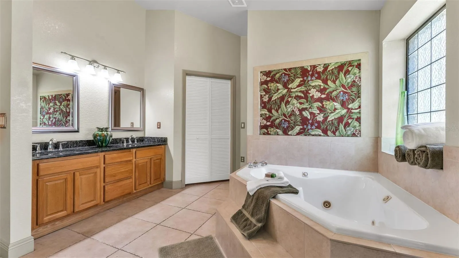 Primary bathroom with jacuzzi, walk in closet straight ahead and water closet to the R