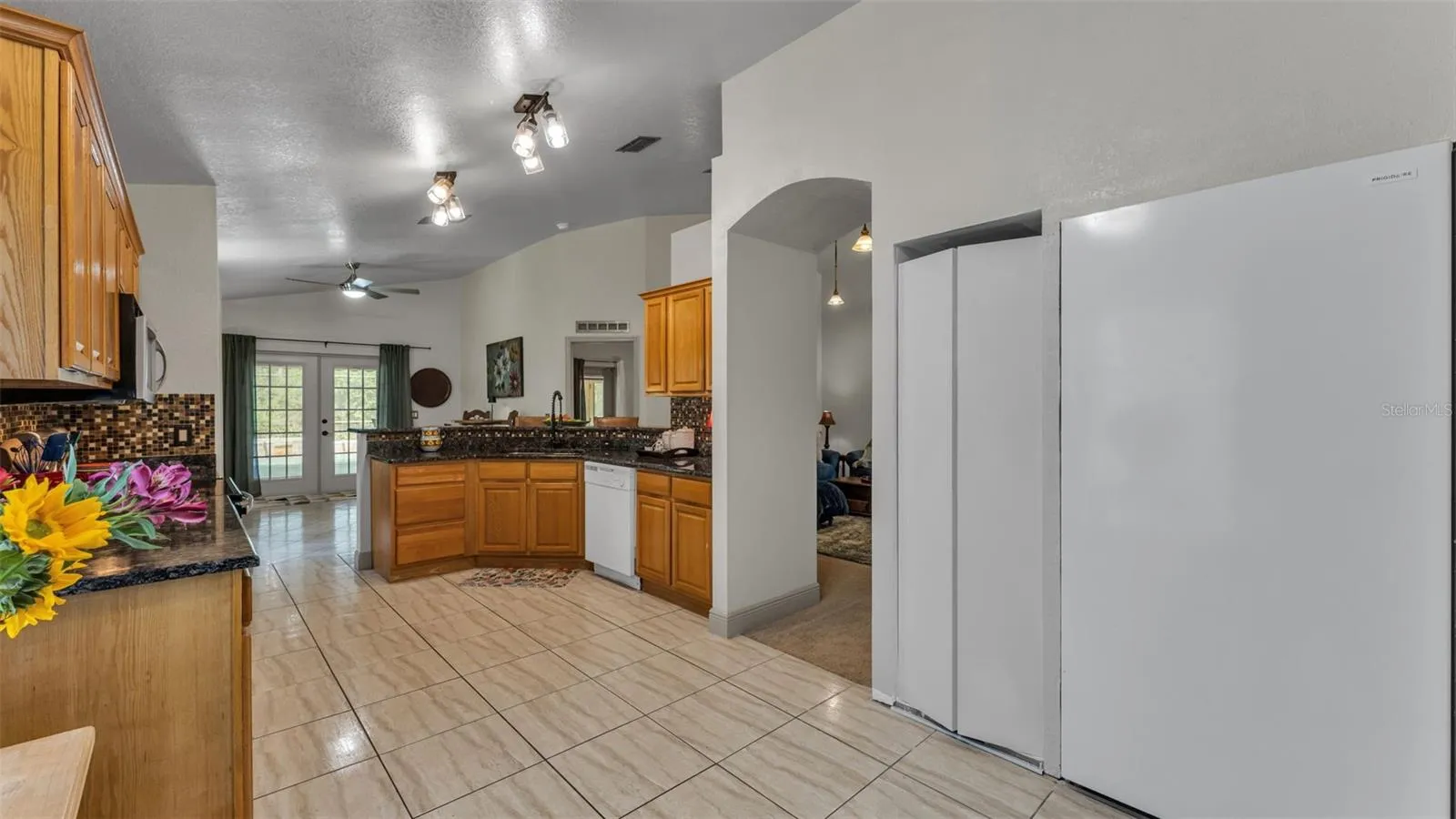 Kitchen towards eating bar and back pool door-LR to the R