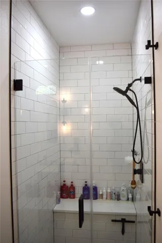 Walk-in Tile Shower has a full glass door and a convenient built in bench.