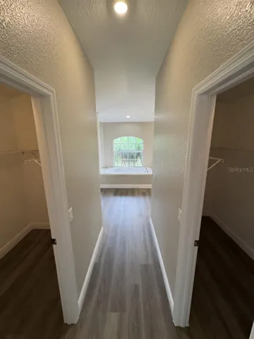 PRIMARY DUAL WALK IN CLOSETS ON EITHER SIDE OF SHORT HALLWAY