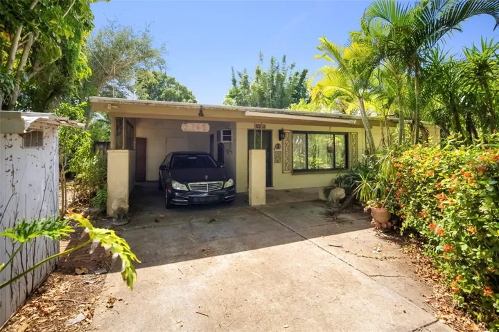 Front of home features spacious carport and mature landscaping