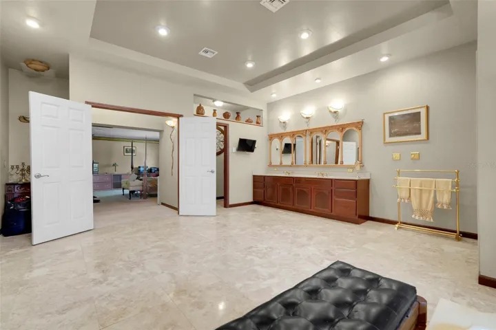 Dual-sink vanity and private water closet enhance the functionality of this sprawling primary bath retreat.