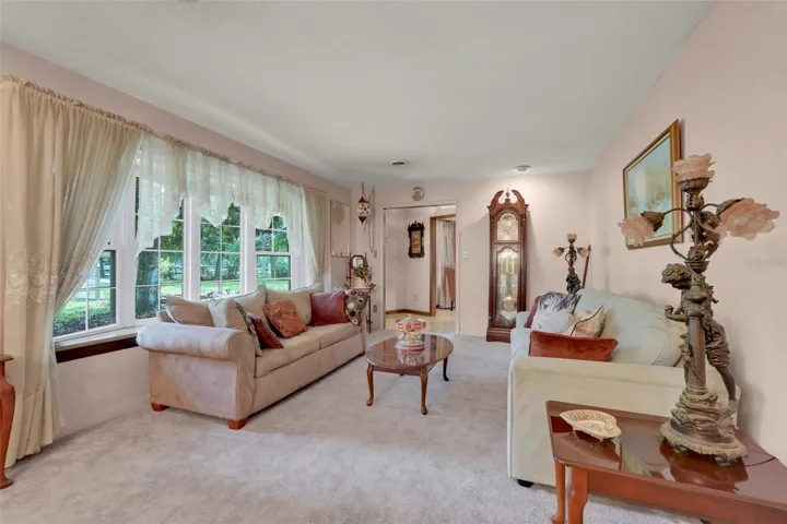 Large bow windows frame beautiful outdoor scenery while filling the formal living space with natural light.